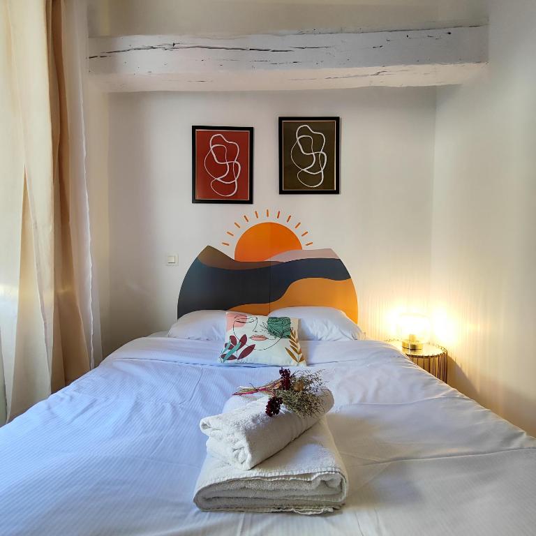 a bedroom with a white bed with a colorful headboard at Numéro 6 - Place Nationale - Wifi et Fibre in Montauban