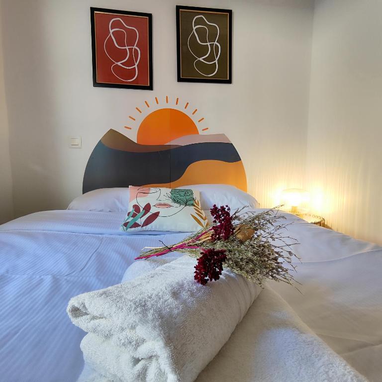 a bedroom with a bed with a flower arrangement on it at Numéro 6 - Place Nationale - Wifi et Fibre in Montauban