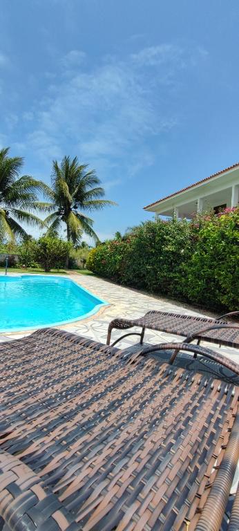 a view of a swimming pool with two lounge chairs at Pousada Sunshine Patacho - Praia do Patacho - Rota Ecológica dos Milagres, Porto de Pedras in Pôrto de Pedras