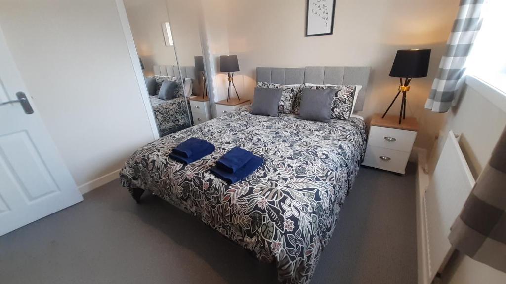 a bedroom with a bed with blue sheets and pillows at Carvetii - Clark House - Spacious ground floor flat in Rosyth