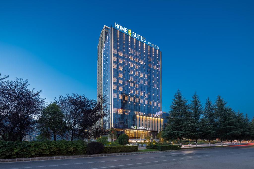 a lit up building with a sign on it at Home2 Suites by Hilton Guiyang Guanshanhu in Guiyang
