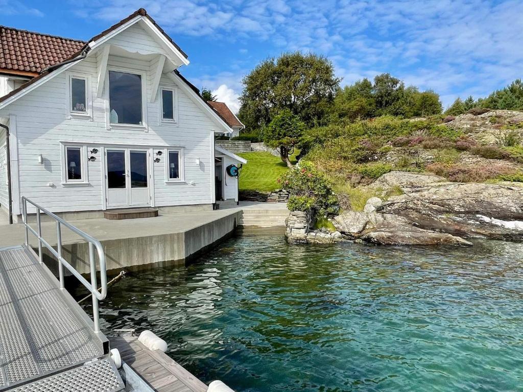 a house on a dock next to a body of water at Holiday home MOSTERHAMN VI in Mosterhamn