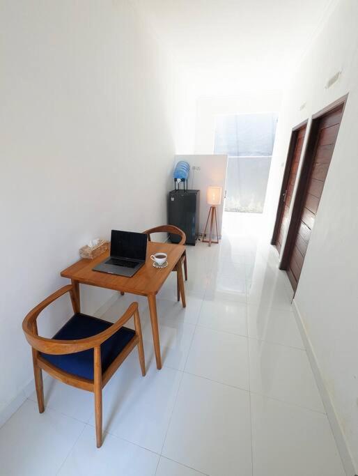 een kamer met een tafel en een laptop op een stoel bij Mini tropical home with office in Krambitan