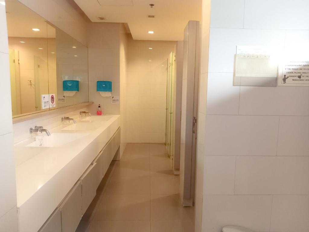 a white bathroom with two sinks and a mirror at Rooms bangkok nearby Onnut bts in Amphoe Phra Khanong