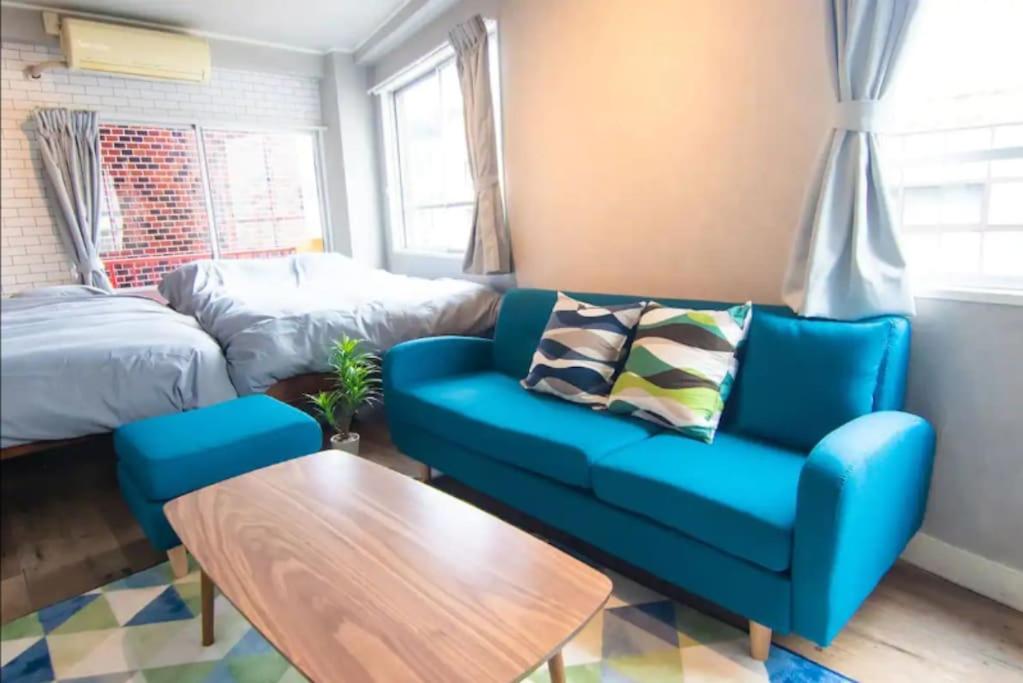 a living room with a blue couch and a table at Yoyogi Apartment 1-401 in Tokyo