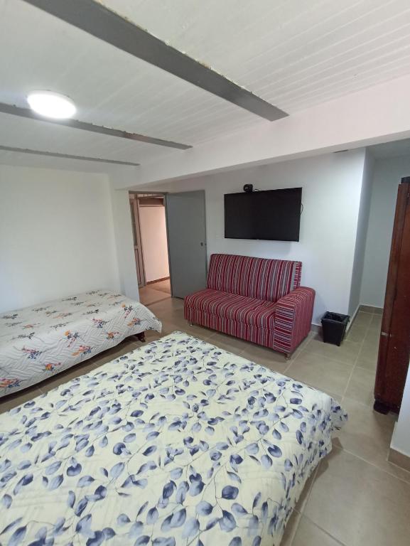 sypialnia z łóżkiem i czerwoną kanapą w obiekcie Apartamento Central w mieście Ibagué