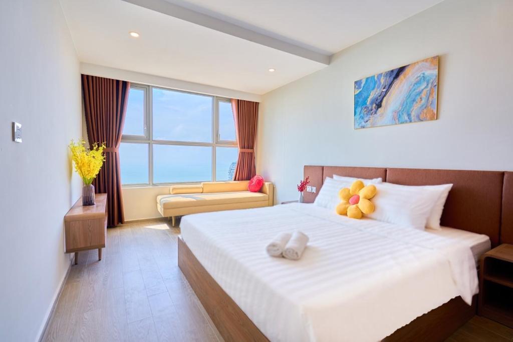 Un dormitorio con una gran cama blanca y una ventana en T-Plantino - Căn hộ Codotel The Sóng 5 Sao - Free swimmingpool, Gym, Sauna en Vung Tau