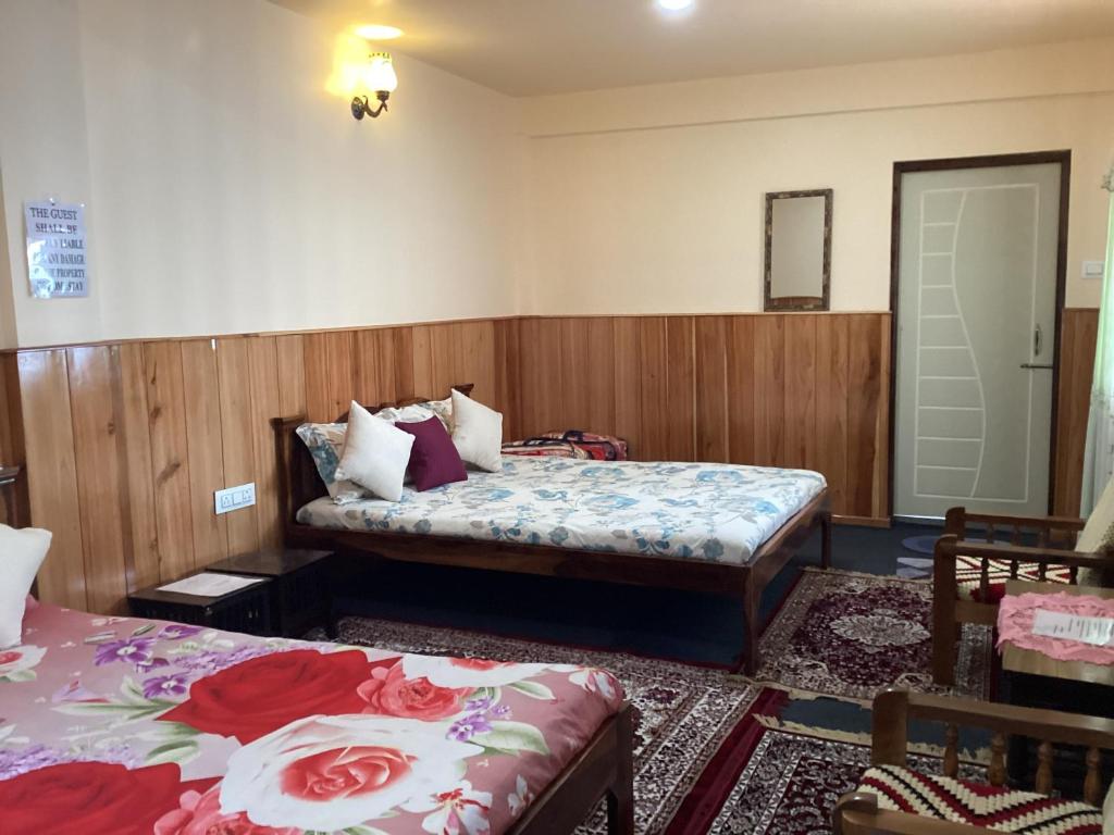 a bedroom with two beds and a couch in it at WARUHANG HOMESTAY in Darjeeling