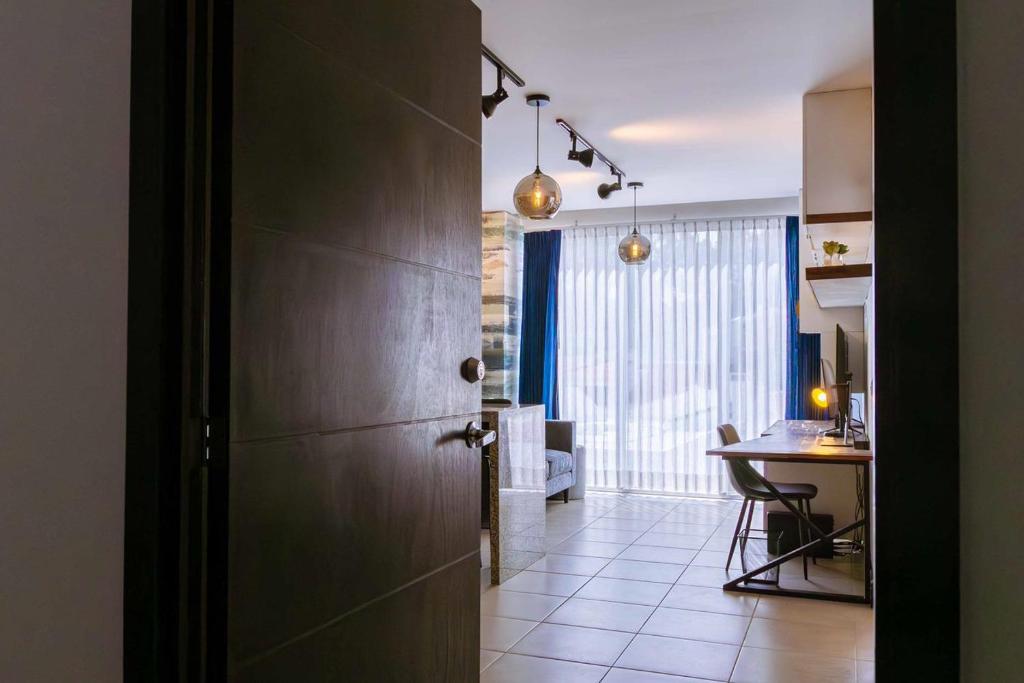 eine Küche mit einem Tisch und einer Tür zu einem Zimmer in der Unterkunft Apartamento a unas cuadras de Condado Concepción Carretera a El Salvador in Guatemala