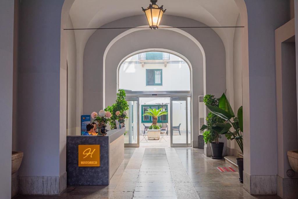 un pasillo abovedado con una entrada con plantas en Historico Loft & Rooms Palazzo Adragna XIX, en Trapani