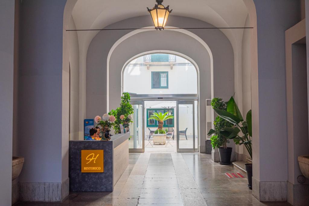 an arched hallway with an entry way with plants at Historico Loft & Rooms Palazzo Adragna XIX in Trapani