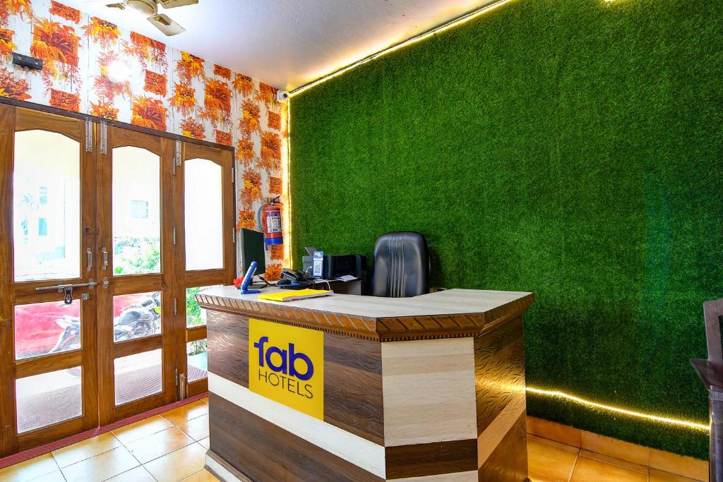 una oficina con un escritorio con una pared verde en FabHotel Bollywood 2.0 en Puri