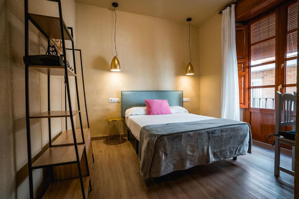 een slaapkamer met een bed met een roze kussen erop bij Veronica Centro in Granada