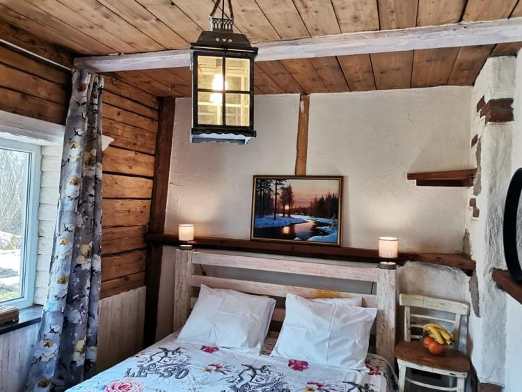 a bedroom with a bed in a wooden cabin at Sagadi Traditional House With The Sauna And Free Parking in Sagadi