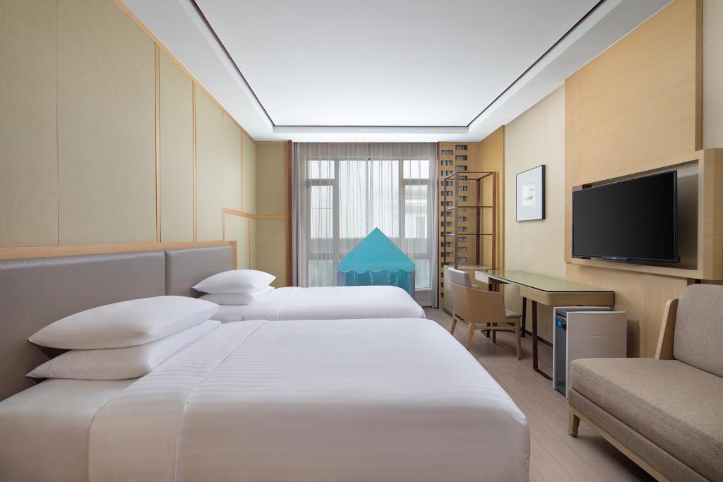 Postel nebo postele na pokoji v ubytování Courtyard by Marriott Shanghai International Tourism and Resorts Zone