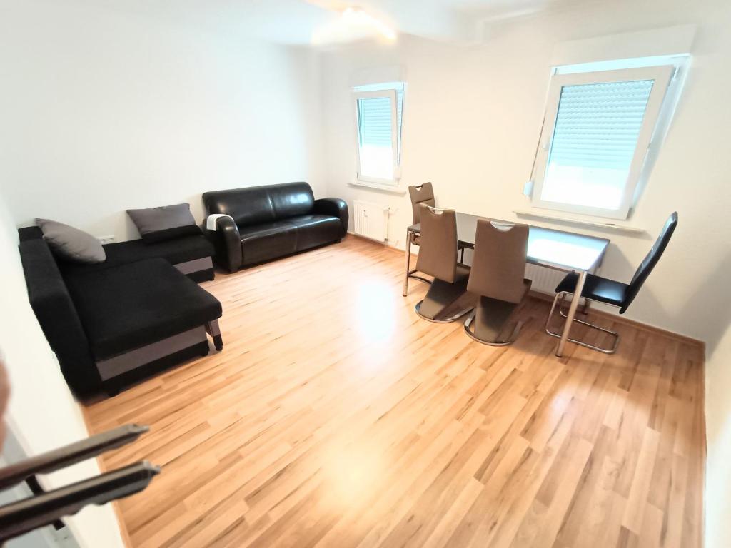 sala de estar con sofá negro y mesa en FMI29,4Zimmer Accommodation en Raunheim