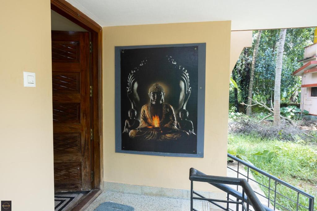 a painting of a buddha on a wall at Reunion Regal Villa in Udupi