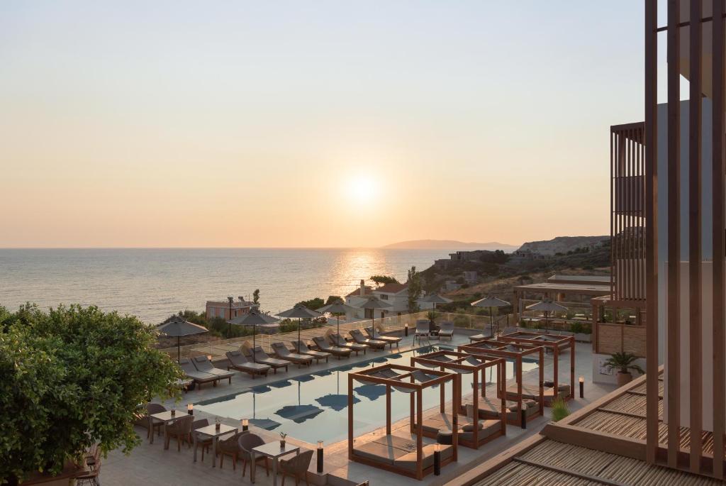 an aerial view of a resort with a pool and the ocean at Irida Hotel Agia Pelagia in Agia Pelagia