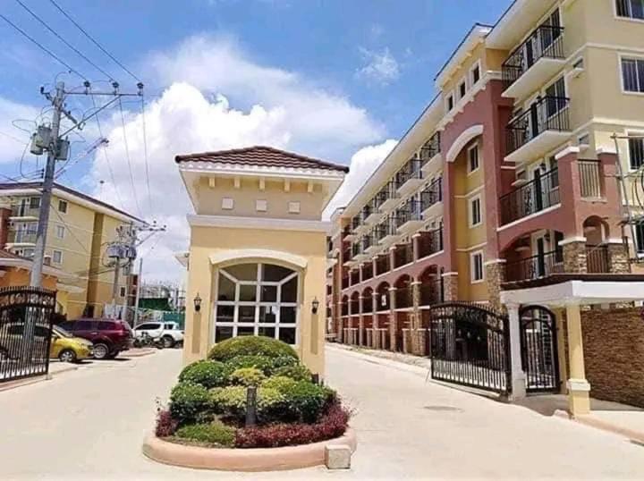 a building on a city street with a building at Cozy Condo in Davao City