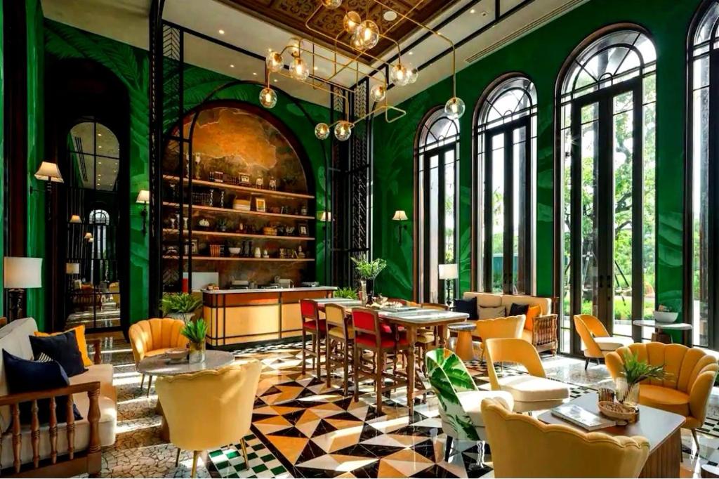 um restaurante com paredes verdes, mesas e cadeiras em Lahabana Resort em Hua Hin
