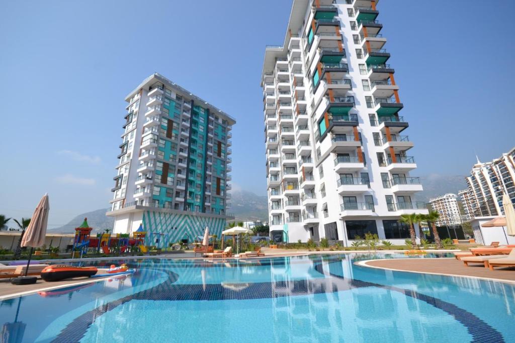 uma piscina em frente a dois edifícios altos em Mahmutlar State of Art em Alanya