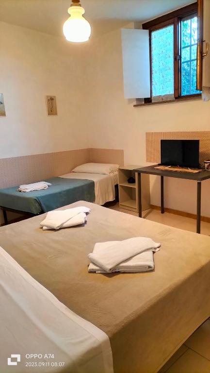 een kamer met 2 bedden en een bureau met een computer bij Apartment Montanelli in Pisa