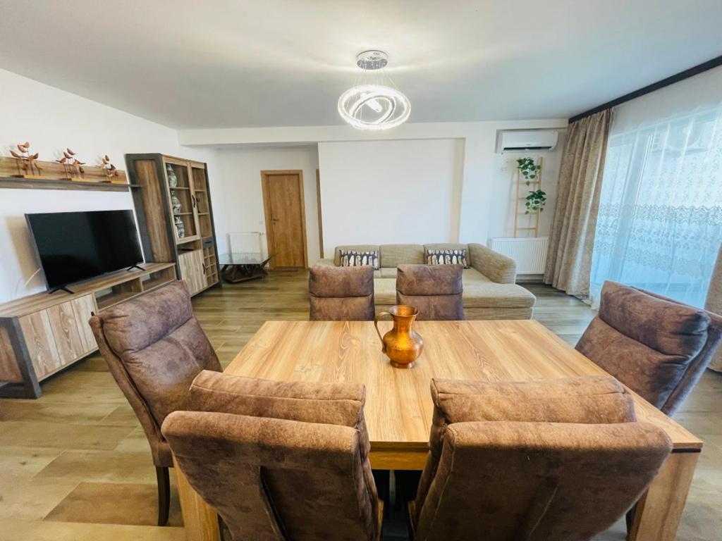 ein Wohnzimmer mit einem Holztisch und Stühlen in der Unterkunft Lilo HOME in Sibiu