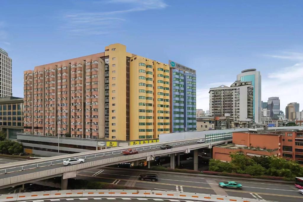 a bridge over a highway in a city with buildings at Wiffton Hotel -Former Tokai Hotel - Xiaobei Metro Station - Free shuttle bus during Canton Fair in Guangzhou