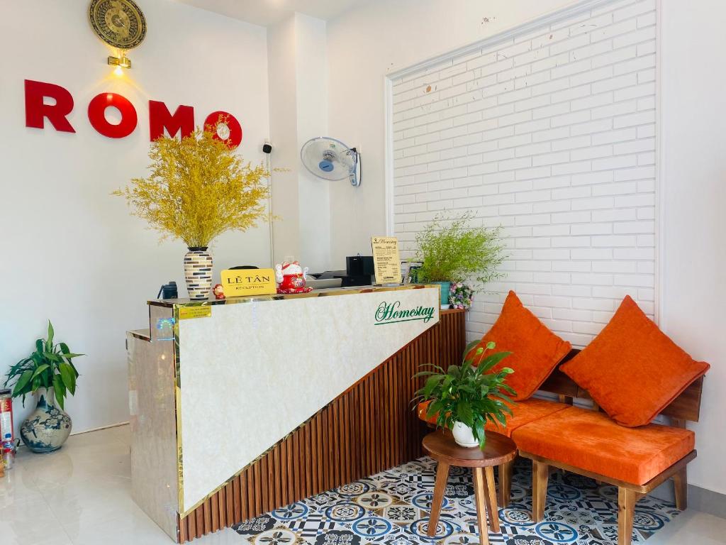una cafetería con una silla naranja y una barra en Romo Homestay en Quang Ngai