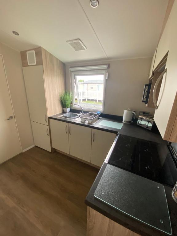 a kitchen with a sink and a counter top at Hughes Holiday Home in St Osyths in Jaywick Sands