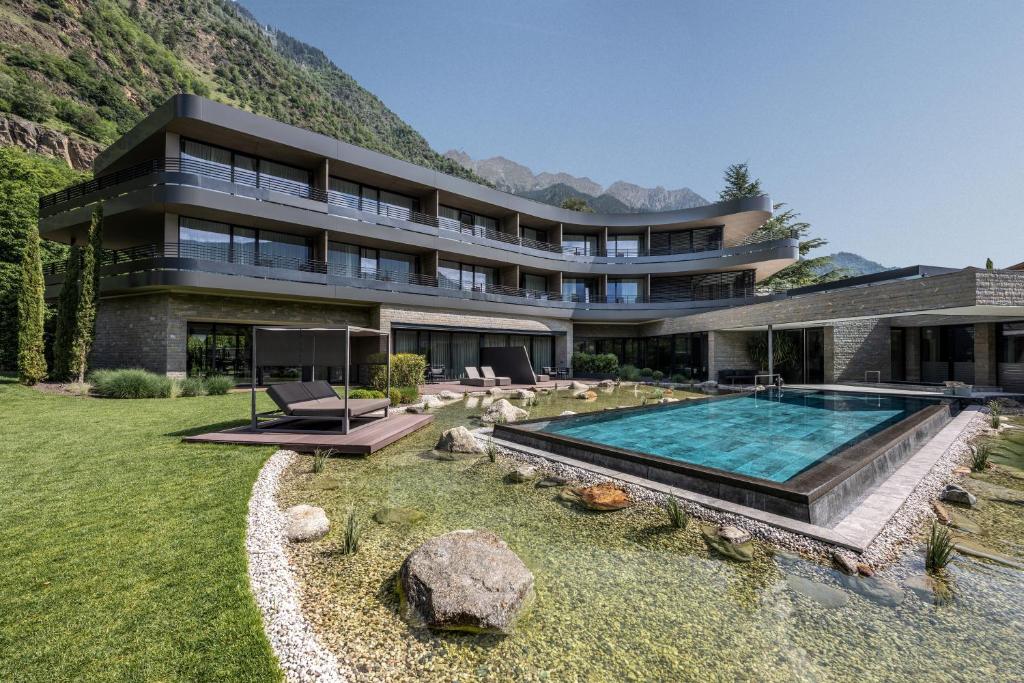 an exterior view of a house with a swimming pool at Klein Fein Hotel Anderlahn in Parcines