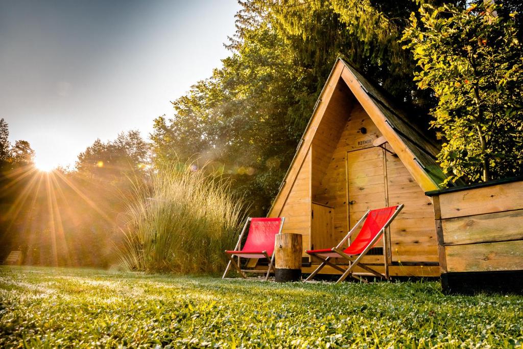 two red chairs sitting in front of a cabin at Glamping FOREST EDGE in Kamnik