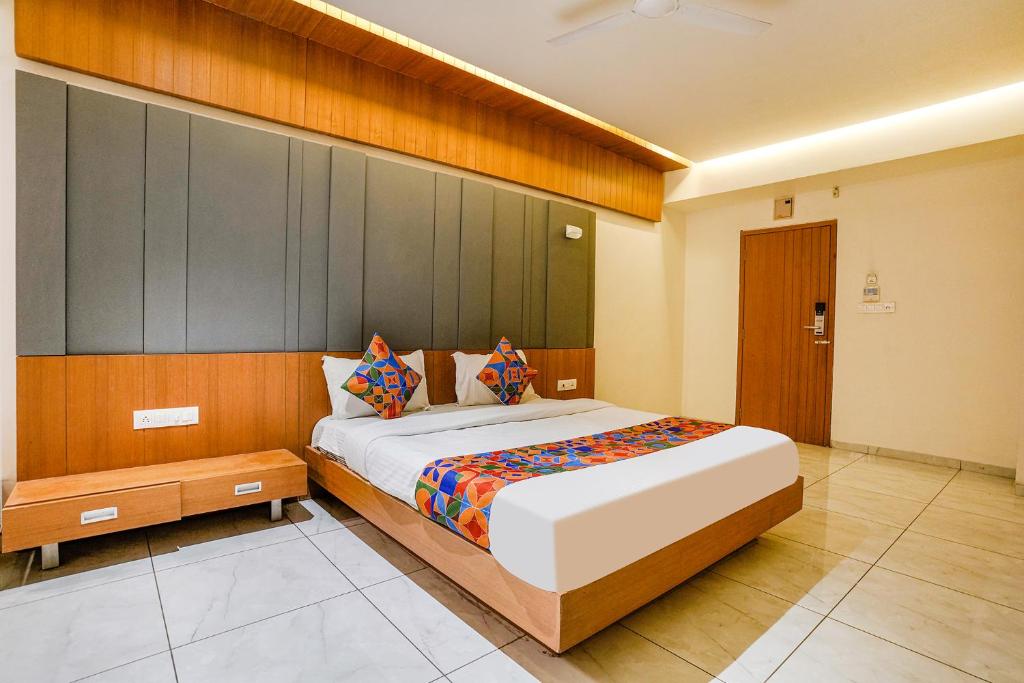 a bedroom with a large bed and a wooden wall at FabHotel Prime Blue Moon in Gandhinagar