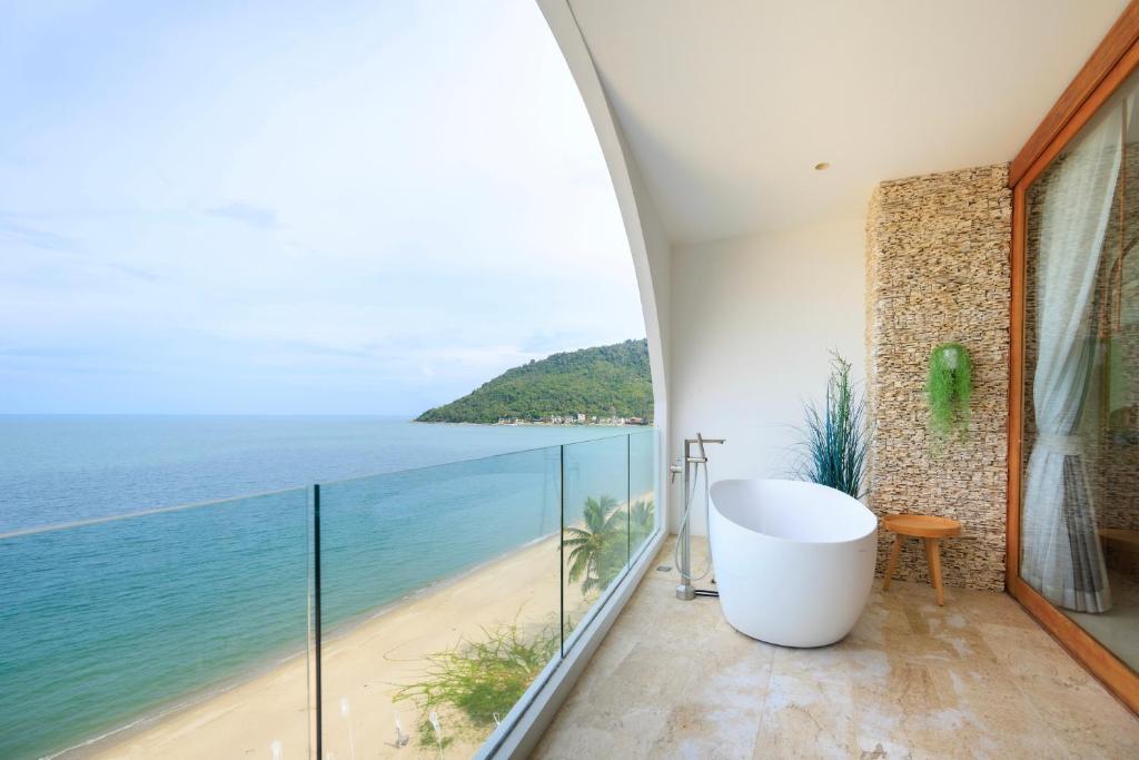 a bathroom with a tub and a view of the ocean at Elite Atoll Khanom - Luxury Coastal Escape in Khanom
