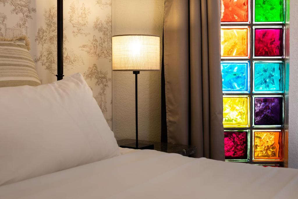 a bedroom with a bed and a colorful window at Best Western L&#39;Orangerie in Nîmes