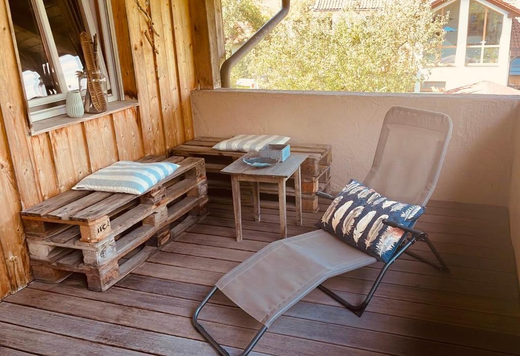 a porch with a bench and a chair and a table at Sonnenuntergang in Traunstein