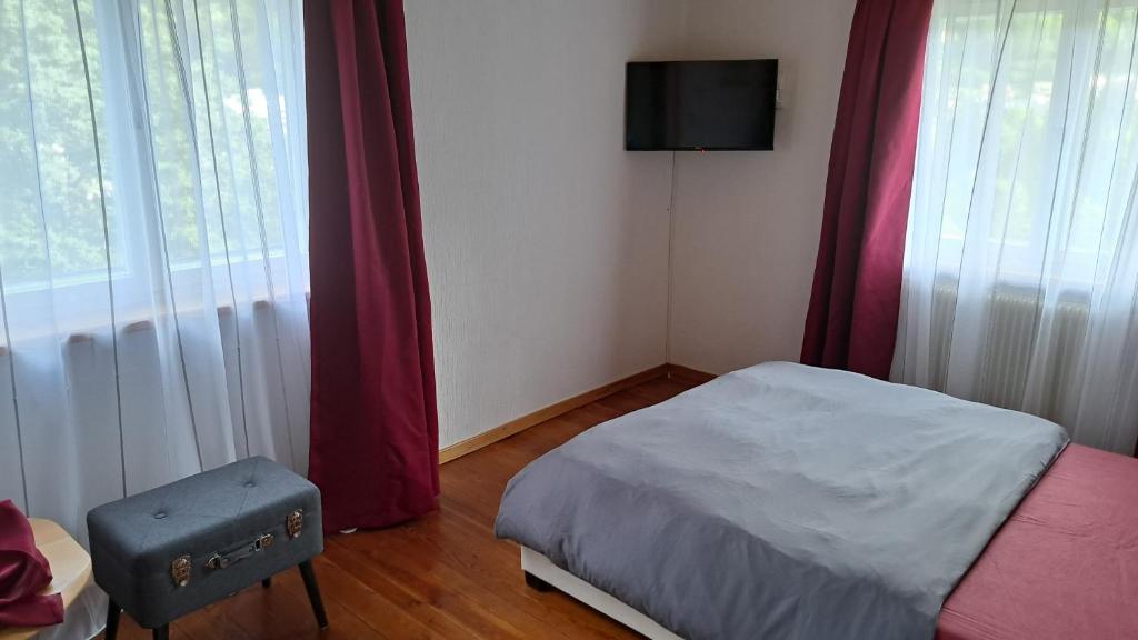 a small bedroom with a bed and a tv on the wall at Wohn-Eitel Romantik in Bad Wildbad