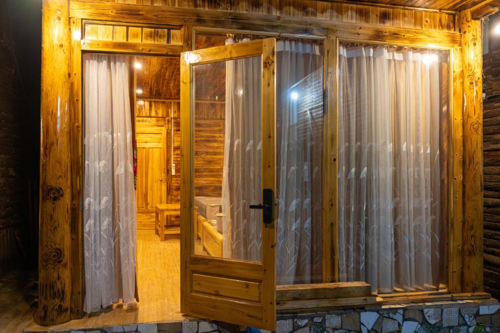 ein Zimmer mit einem Fenster mit Vorhängen darauf in der Unterkunft Hoa Chanh Bungalow in Sa Pa