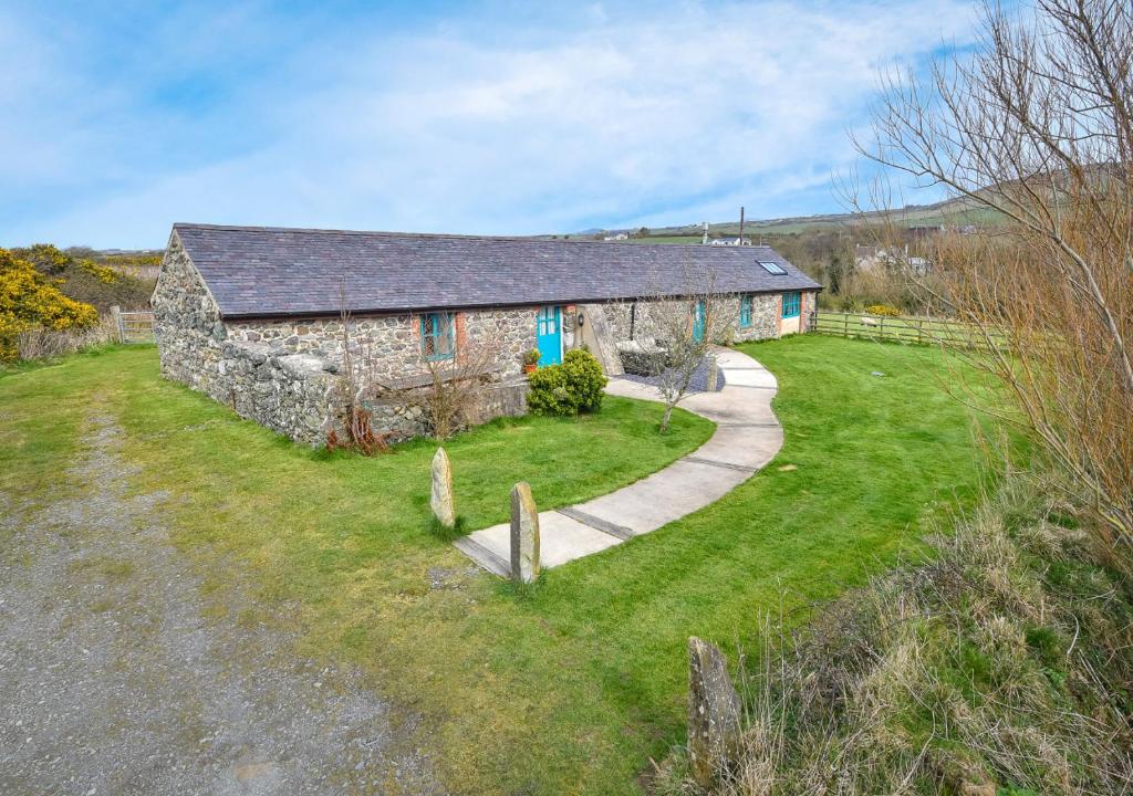 an old stone barn with a path in front of it at Ty Cam in Aberdaron