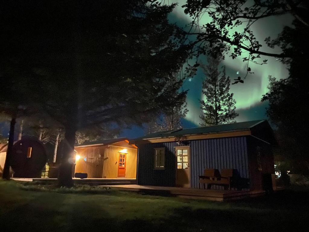 una piccola cabina notturna con luci accese di Backyard Village a Hveragerði
