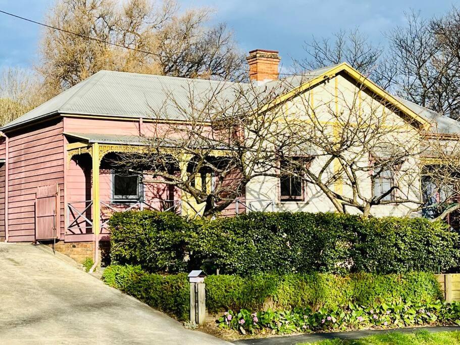 a large house with a pink house at Quarryman Cottage @ 102 in Bowral
