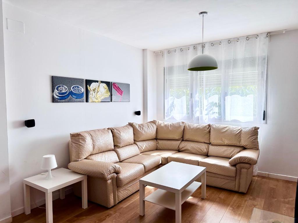 een woonkamer met een bank en een tafel bij Luminoso Apartamento a 10 minutos de Granada con Piscina in Alhendín