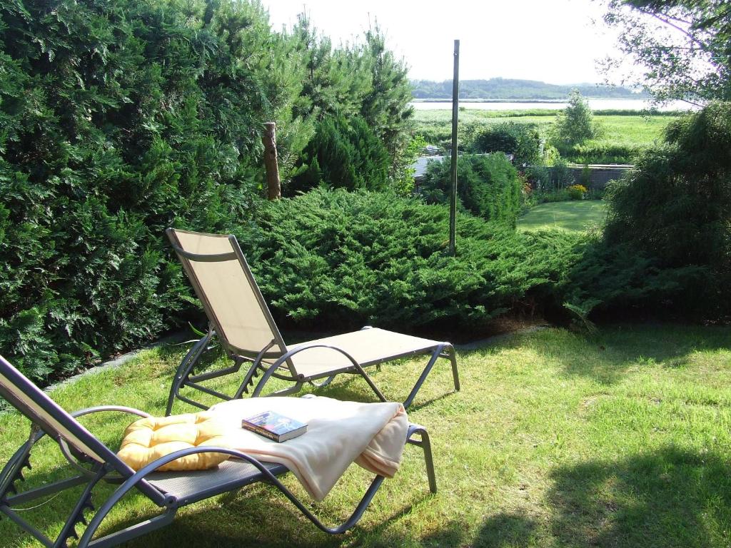 a chair sitting on the grass in a yard at Balm, Fewo "Balmer See" in Balm