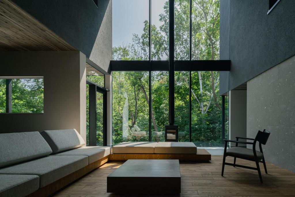 ein Wohnzimmer mit einem Sofa und einem großen Fenster in der Unterkunft The VILLA SHUN in Otaru