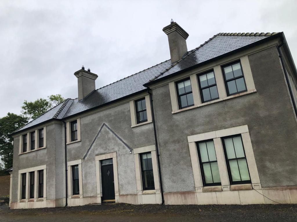 an old gray house with a black roof at Country house in Killyhevlin