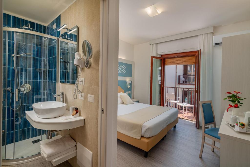 a bedroom with a bed and a sink and a shower at Hotel El Balear in Alghero
