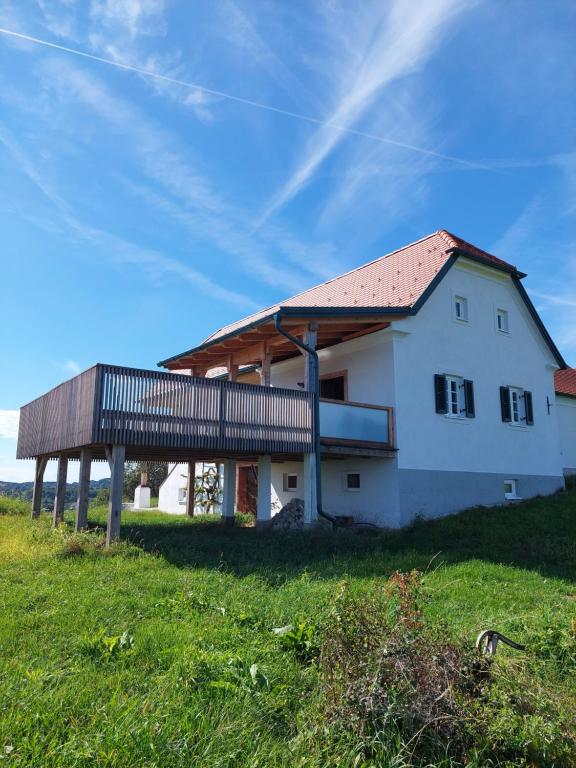 een wit huis met een terras op een groen veld bij Baronigg Weingartengut 