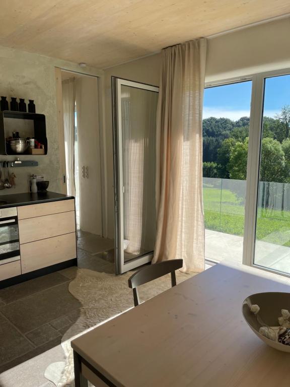 una cucina con tavolo e una grande finestra di Sunhand home a Eibiswald