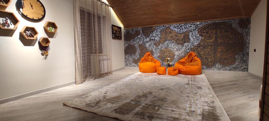 two orange chairs sitting on a rug in a room at Villa Vishnyovka in Baku