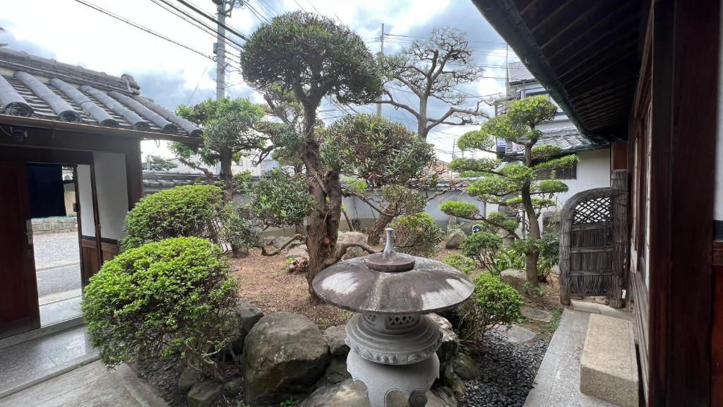 un jardín con un baño de aves frente a un edificio en 和風庭園豪邸 en Osaka